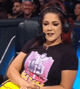 a woman wearing headphones and a t-shirt with a picture of a group of girls on it