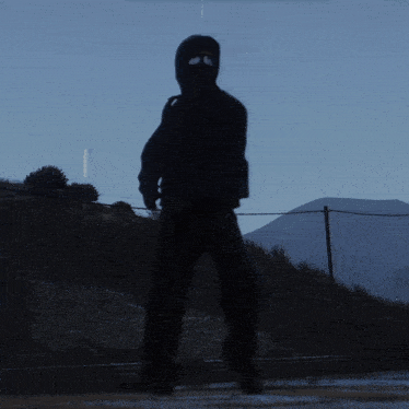 a silhouette of a man wearing a mask and a gun