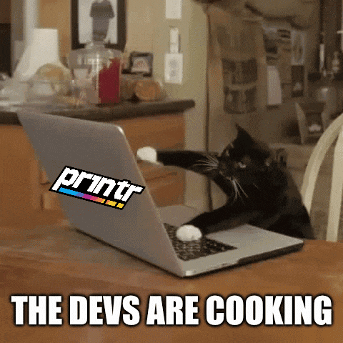 a black cat is using a laptop with a printr sticker on it