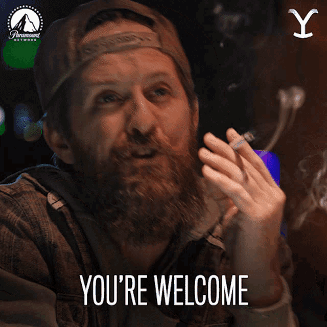 a man with a beard says " you 're welcome " while smoking a cigarette