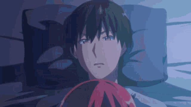 a man with green hair is laying in bed with a red haired girl