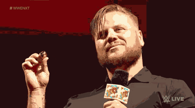 a man with a beard is wearing a microphone that says wwe live on it