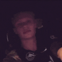 a young man wearing a shirt that says ' cowboys ' on it is sitting in a car