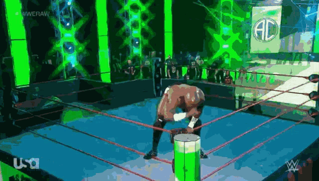 a man in a wrestling ring with a green barrel in front of him