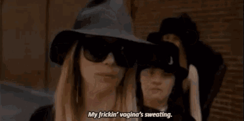a woman wearing a hat and sunglasses is standing next to two other women wearing hats and sunglasses .