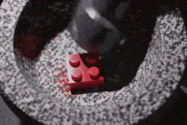 a red lego brick is being smashed by a hammer