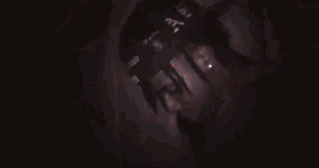 a close up of a person 's face in a dark room with a red background .