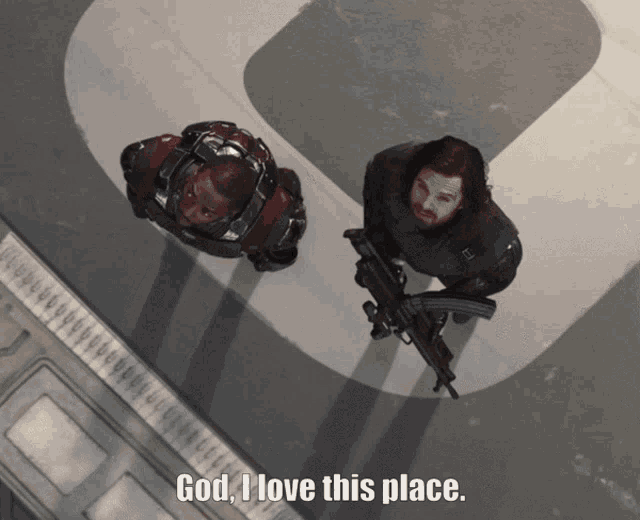 a man with a gun is standing next to another man with the words god i love this place