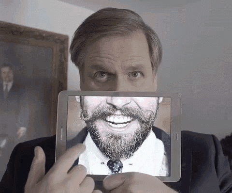 a man holding a tablet with a picture of a man with a beard