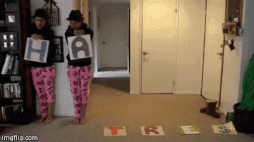 two women in pajamas holding up signs that say " hate " and " free "