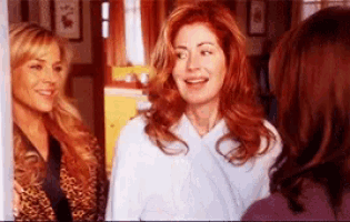 three women are standing next to each other and one of them is smiling .