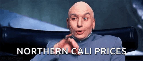 a bald man is sitting in a chair and pointing at the camera with the words northern cali prices written below him .