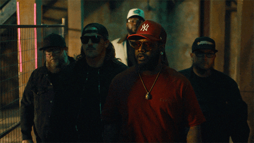 a group of men wearing ny hats and sunglasses are standing in a line