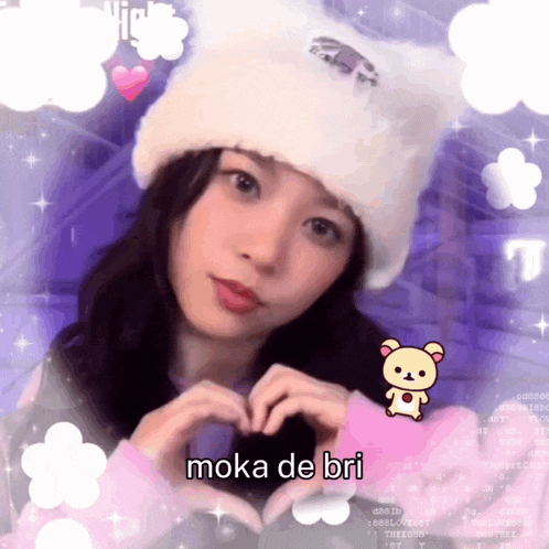 a girl in a white hat making a heart with her hands and the words moka de bri