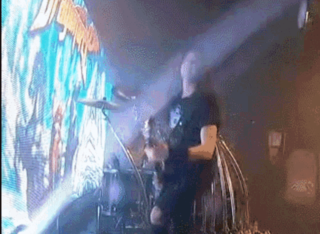a man playing drums in front of a large screen that says ' exit ' on it