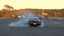 a car is drifting down a road with smoke coming out of the tires