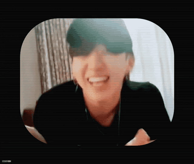 a man wearing a black hat and a necklace is laughing with his tongue out