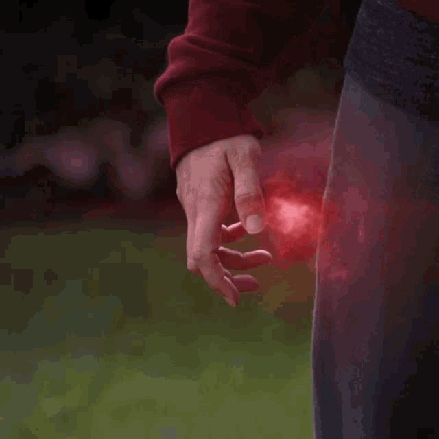 a close up of a person 's hand with a red glow