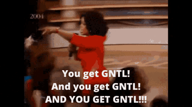 a woman in a red shirt stands in front of a crowd and says you get gntl and you get gntl