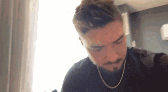 a man with a beard is wearing a chain around his neck