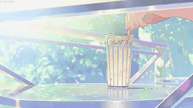 a person pouring a drink into a glass with a straw