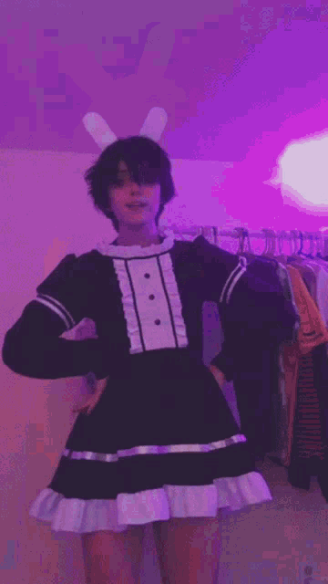 a person wearing bunny ears and a maid costume is dancing .