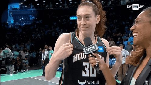 a woman wearing a new york jersey is being interviewed