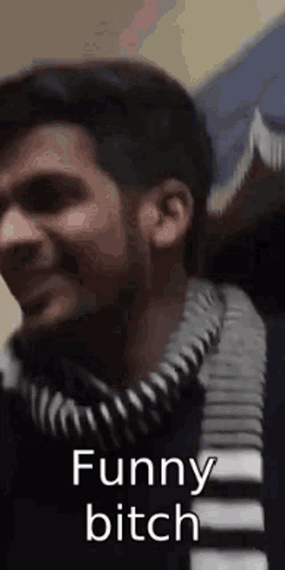 a man wearing a scarf and a sweater is making a funny face .
