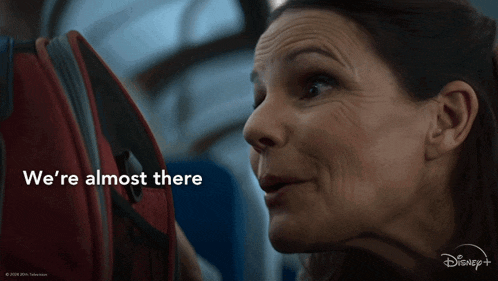 a woman looking at a suitcase with the words we 're almost there