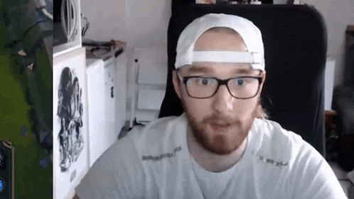 a man with a beard is wearing glasses and a white hat .