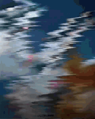 a blurry picture of a body of water with a blue sky and clouds in the background