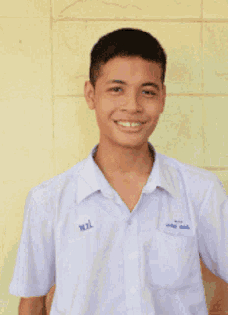 a young man wearing a white shirt with the name w.l. on the collar