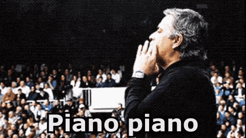 a man covering his mouth with his hands in front of a crowd with the words piano piano on the bottom
