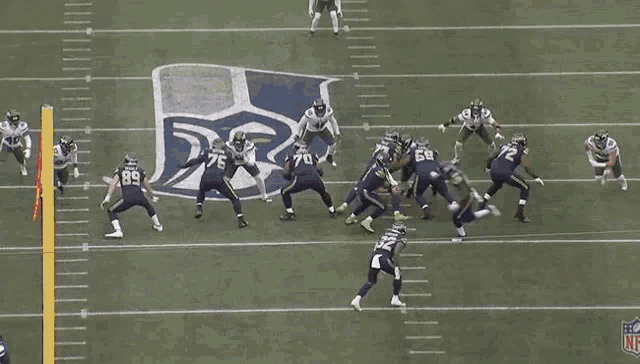a football game is being played on a field with the nfl logo on the sideline