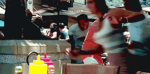 a blurred image of people sitting at a table with condiments on it