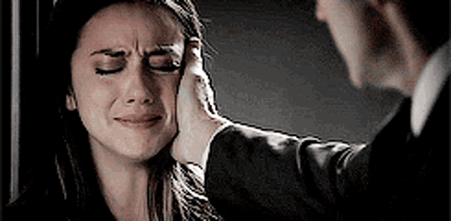 a man is putting his hand on a woman 's face .