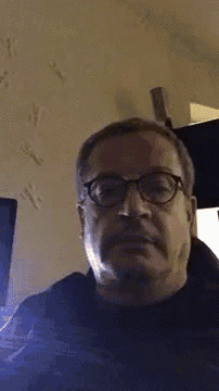 a man with glasses and a mustache is making a face .