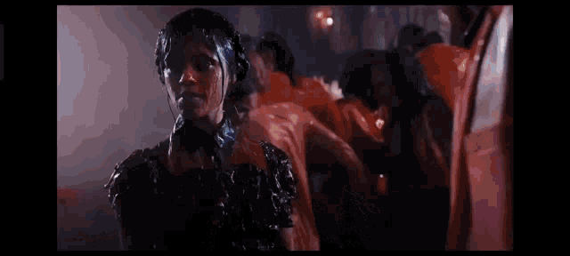 a woman in a black dress is covered in liquid .