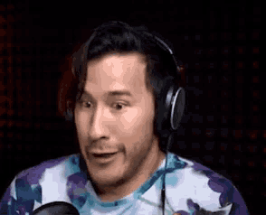 a man wearing headphones is talking into a microphone .