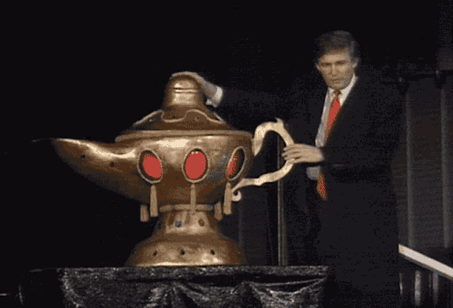 a man in a suit and red tie is standing next to a giant lamp