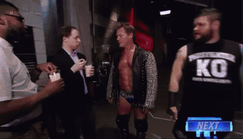 a man wearing a ko tank top talks to another man