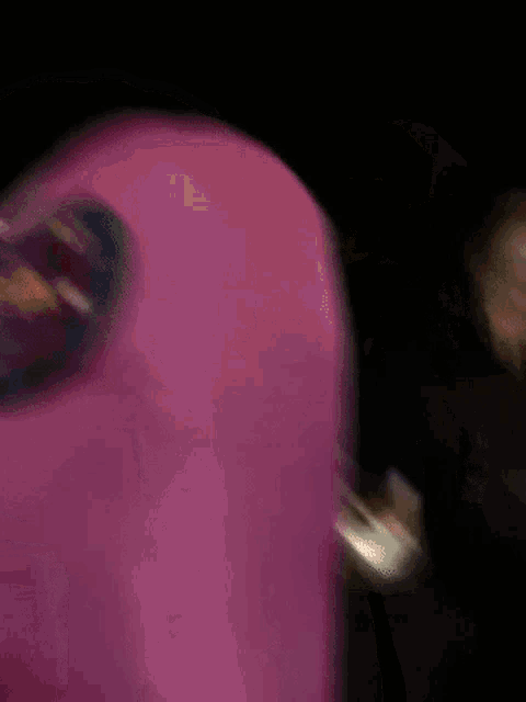 a man in a pink among us costume is standing next to a man in a white mask
