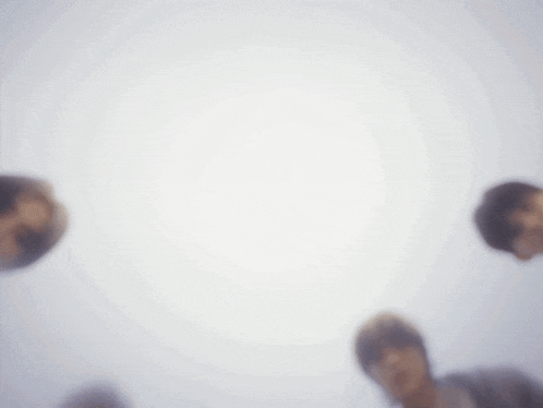 a group of people standing in a circle looking up at the camera .