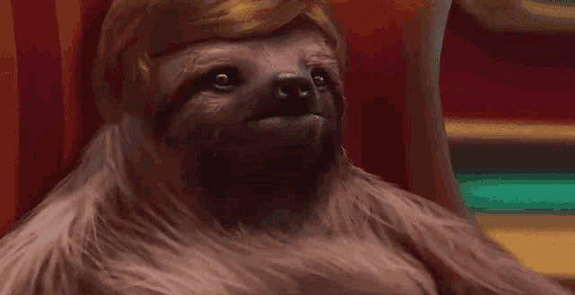 a sloth is wearing a wig and sitting in a chair .
