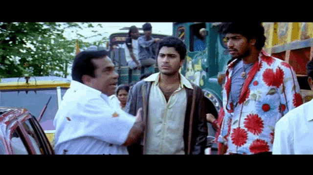 a man in a floral shirt is talking to a man in a white shirt