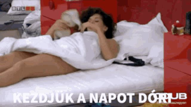 a naked woman laying on a bed with the words kezdjuk a napot dorujb written on the bottom