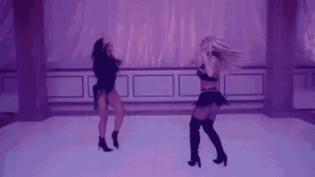 two women are dancing together on a dance floor in a room with purple lights .