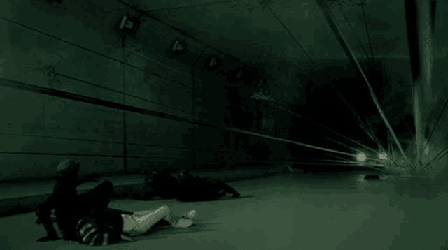 a group of people are laying on the ground in a tunnel .