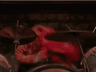 a muppet is playing the drums in a band .