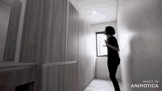 a woman standing in a hallway with the words made in animotica on the bottom